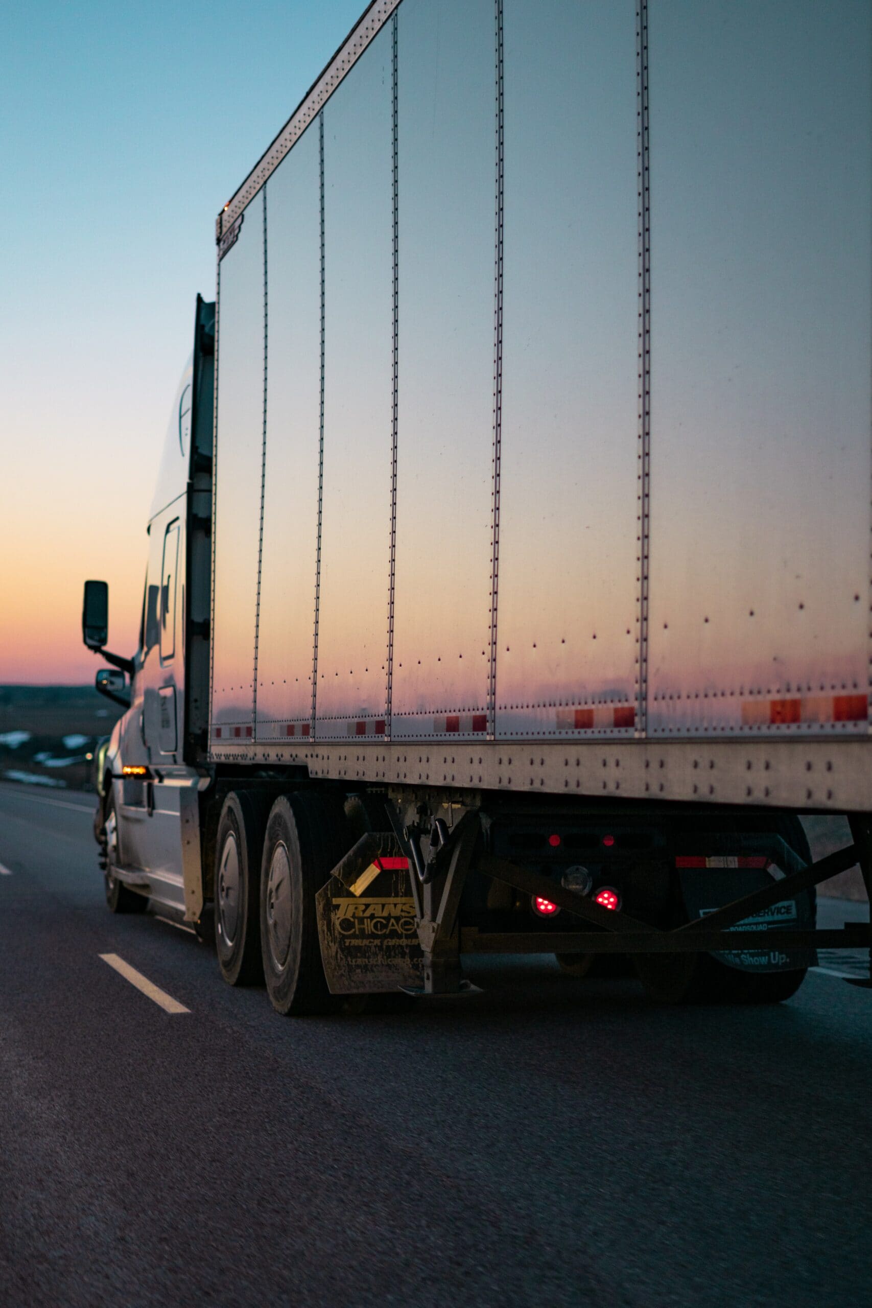 Trucker driving in the sunset wondering about switching careers to owner operator